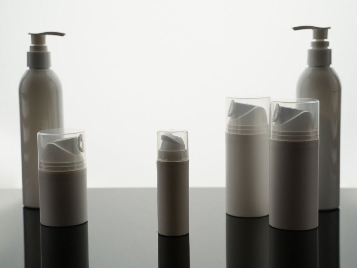 Skincare and cosmetic pump bottles on a clean surface